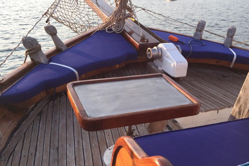 Bitez'de kiralık özel teknenin lacivert minderli ve ahşap sehpalı pruva güvertesi.Teknemizin baş kısmında, uçsuz bucaksız denize karşı en güzel tatil anılarınızı fotoğraflayabilir, sevdiklerinizle özel bir akşamüstü sohbetine dalabilirsiniz