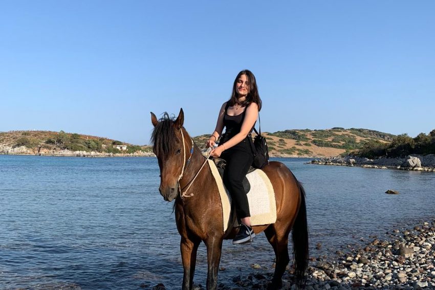 Plajda Bodrum at safari turu ve suyun içinde at binme deneyimi yaşayan mutlu turist.