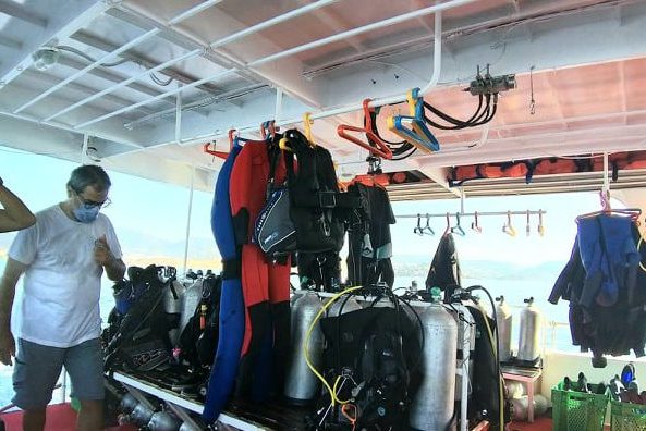Bodrum dalış teknesinde asılı dalış kıyafetleri ve hazırlanan dalış tüpleri.