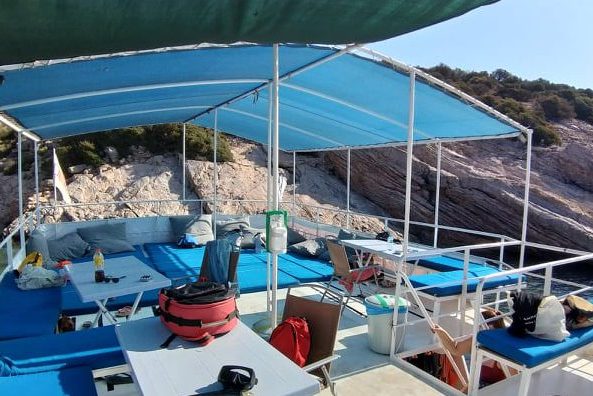 Profesyonel Bodrum dalış turu deneyimi sunan teknemizin, dalgıçlar ve misafirler için özel olarak hazırlanmış gölgelikli ve minderli üst güverte oturma düzeni.
